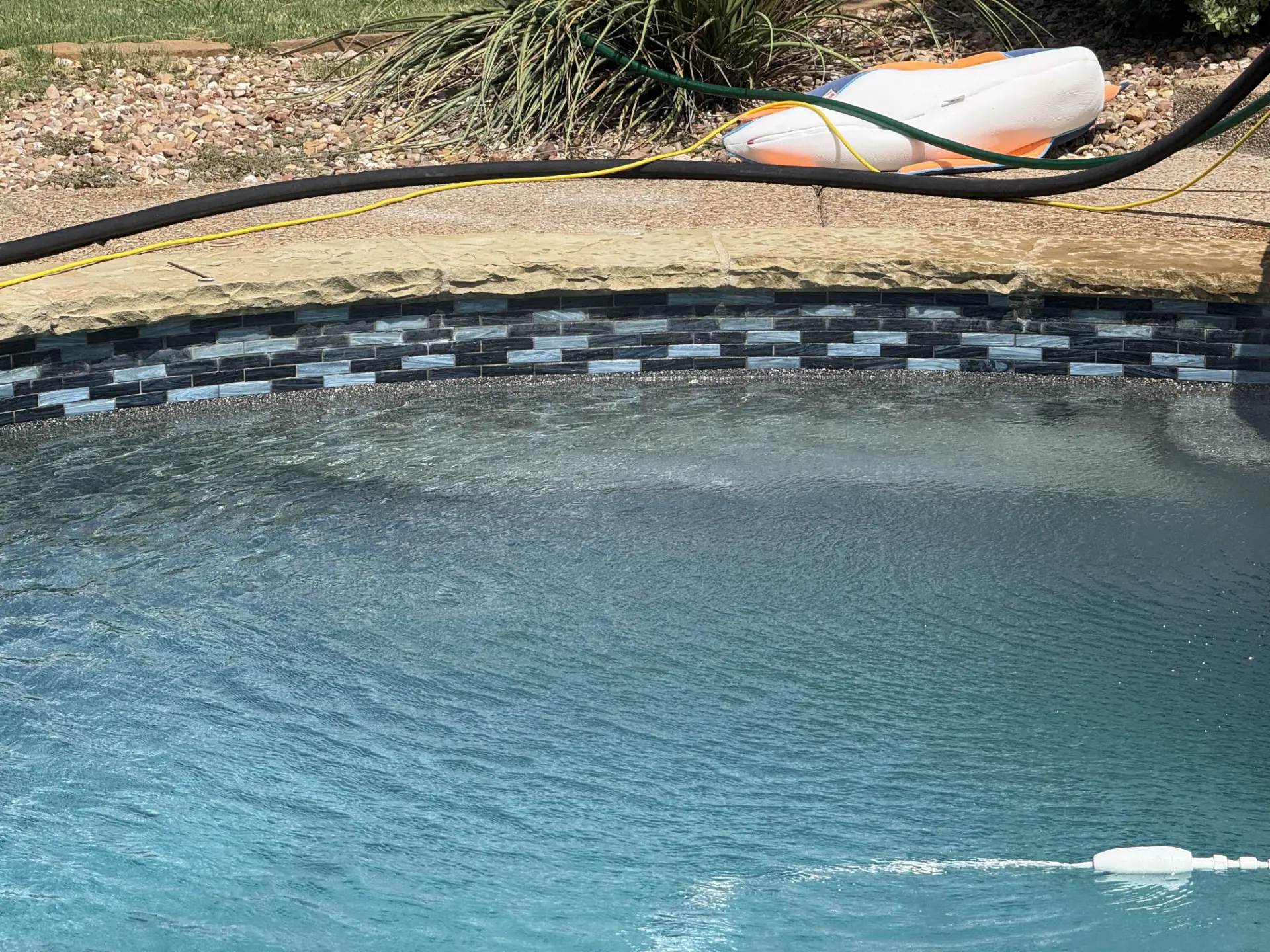 Restored mosaic tile band along a pool edge